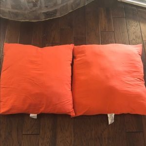Two 25x25 orange throw pillows